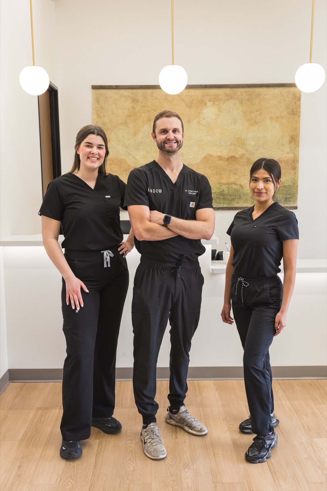 The Tänder surgical team — a board-certified oral surgeon and two assistants in Tänder scrubs — at a partner dental practice